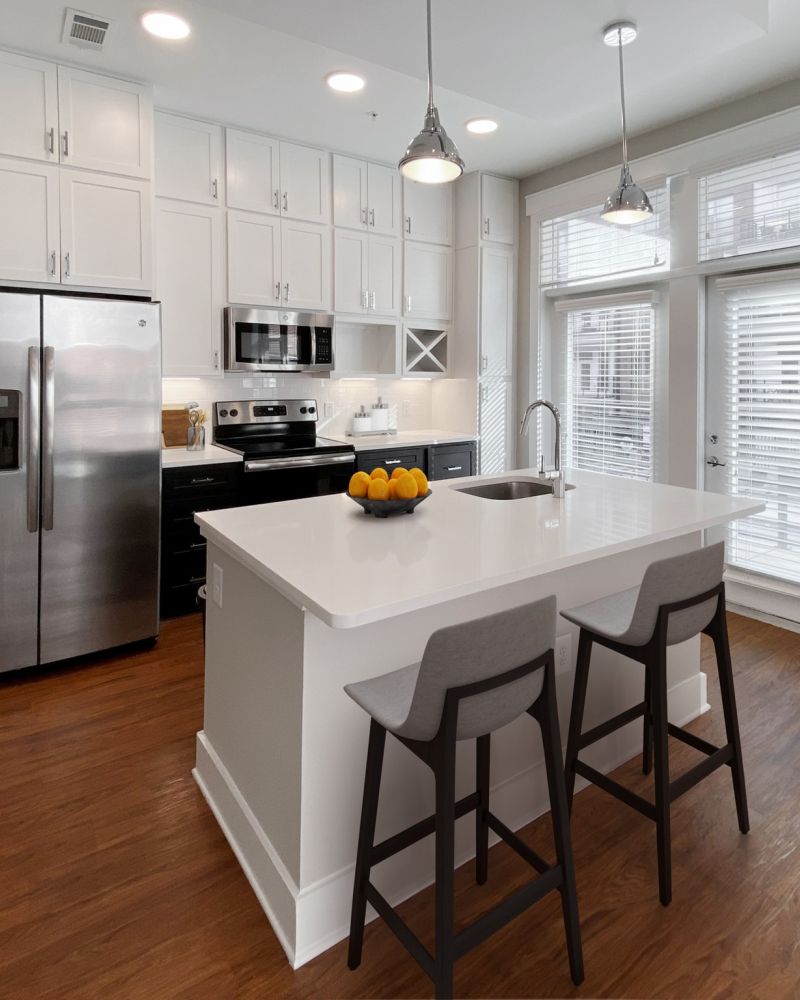 Van Alen apartments in Downtown Durham NC bright kitchen with custom cabinetry, recessed lighting, and kitchen island