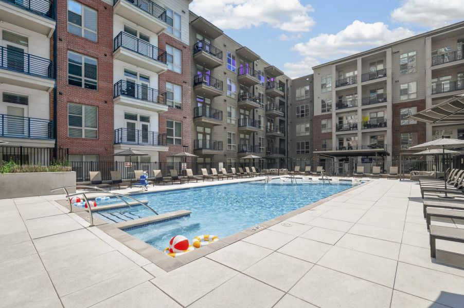Van Alen apartments resort-inspired pool with in-pool lounge seating and surround lounge chairs and umbrellas